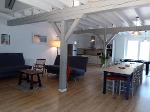 a living room with a table and a dining room at La Grange Landaise in Laglorieuse