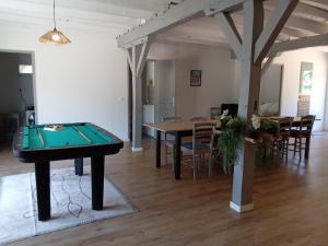 a room with a ping pong table and a dining room at La Grange Landaise in Laglorieuse