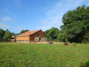 a barn in a field next to a grassy field at La Grange Landaise in Laglorieuse