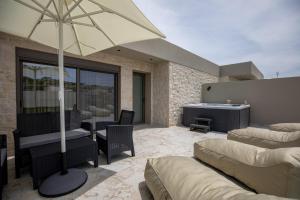 a patio with a table and an umbrella at Santerra Suites in Rhodes Town