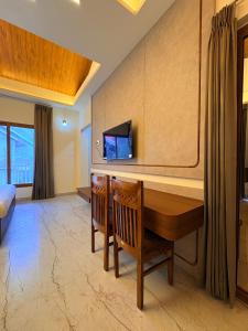 a room with a desk and a tv on the wall at Sittong Aura in Kurseong