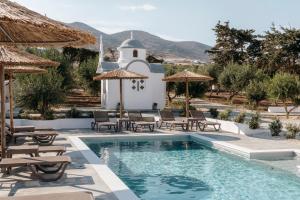 a pool at a resort with chairs and umbrellas at Paranthos Island Living in Chrissi Akti