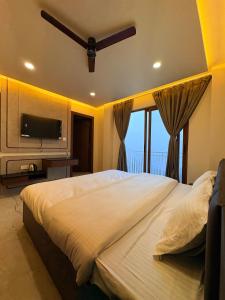 a bedroom with a large bed and a television at Sittong Aura in Kurseong