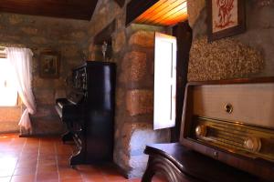 a living room with a piano and a television at Quinta da Graca- Complexo Turistico in Resende