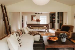 a living room with a white couch and a piano at Wren Cottage - Design Cabin with Secret Brook in Cochecton