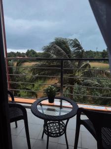 a table and chairs on a balcony with palm trees at Sunset view apartment with a pool MAIKHAO Phuket in Ban Mai Salae