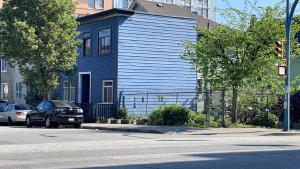 a blue house on the side of a street at Vancouver east downtown queen bed room share bathroom in Vancouver +13 photos