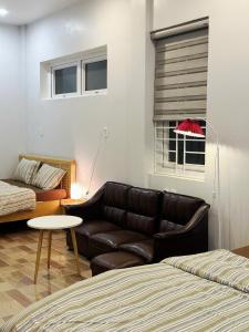a living room with a leather couch and a table at Viha Homestay in Thôn Trường Giang