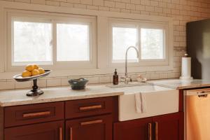 a kitchen with a sink and two windows at Wren Cottage - Design Cabin with Secret Brook in Cochecton +44 photos