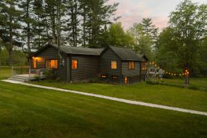 a small house in a yard with lights on it at Wren Cottage - Design Cabin with Secret Brook in Cochecton