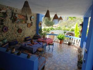a living room with two tables and a balcony at Blue House Town in Chefchaouen