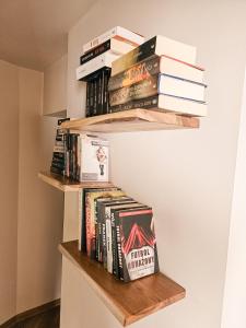 a stack of books on shelves in a room at Check in Silence in Tylicz
