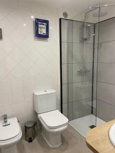a bathroom with a toilet and a glass shower at Caparica Sol&Mar Apartment in Costa da Caparica +22 photos