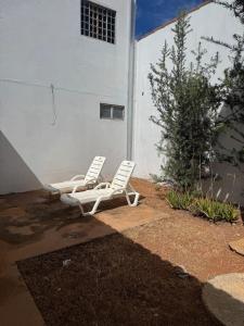 two white chairs sitting in front of a building at Palmeira House in Formosa