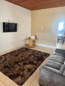 a living room with a couch and a flat screen tv at Palmeira House in Formosa
