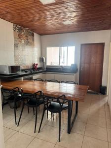 a large kitchen with a wooden table and chairs at Palmeira House in Formosa