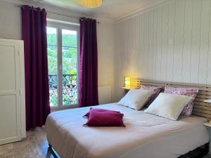a bedroom with a large bed with purple curtains at Le 130 - 1 chambre - Wifi - Proche Parc Thermal - 2 personnes in Châtel-Guyon
