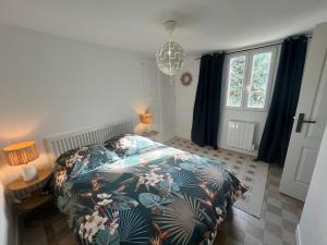 a bedroom with a bed with a floral bedspread at L'Annexe du Piton in Sancerre