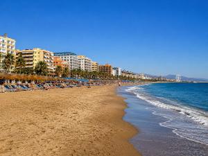 a beach with a lot of people and the ocean at Central Torremolinos Luxury Apartment in Torremolinos