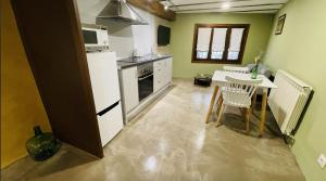 a kitchen with a white refrigerator and a table at Casa O'Tinte in Alquézar +5 photos