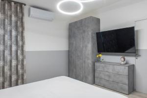 a bedroom with a bed and a flat screen tv at PETIT casa vacanze in Loreto
