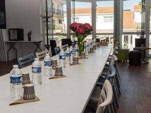 a long table with bottles of water and flowers on it at ibis Styles St Gilles Croix de Vie centre-ville in Saint-Gilles-Croix-de-Vie +178 photos