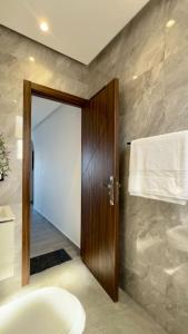 a bathroom with a wooden door and a sink at KAZA Aouchtame 2 in Laʼzîb +12 photos