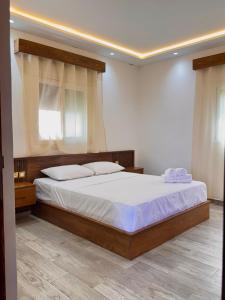 a bedroom with a bed with white sheets and a window at KAZA Aouchtame 2 in Laʼzîb