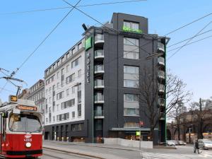 a red tram in front of a building at Ibis Styles Wien City in Vienna