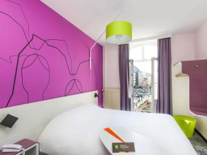 a bedroom with a white bed and a pink wall at ibis Styles Strasbourg Centre Petite France in Strasbourg