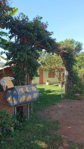 a blue bench sitting under a tree in a yard at Pousada Encanto dos Olhos in Alexânia