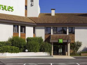 a hotel with a sign on the side of a building at ibis Styles Niort Poitou Charentes in Vouillé