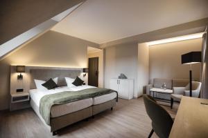 a bedroom with a bed and a desk and a chair at Seehotel Heidehof in Klein Nemerow