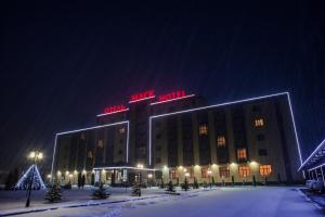een groot gebouw met neonborden erop bij Mask Business Hotel in Pyatigorsk