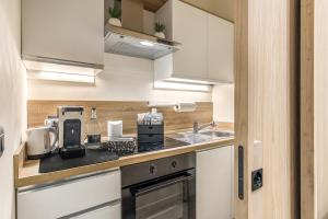 a kitchen with white cabinets and a counter top at Grafea - Luxury stay in Catania in Catania