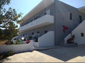 a large white building with stairs and flowers at Olive apartment in Adelianos Kampos