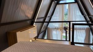 a bedroom with a bed and a large window at Cabana WSA Piratuba SC in Piratuba