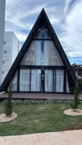 a triangular house with a window and two trees at Cabana WSA Piratuba SC in Piratuba