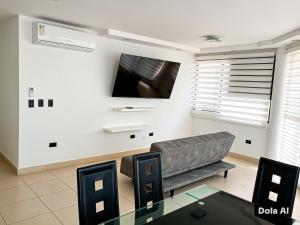 a living room with a couch and a tv at Tonsupa Playa Almendro in Tonsupa