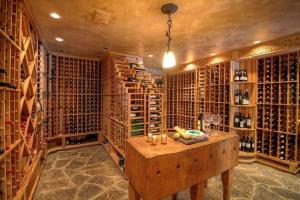 a wine cellar with a wooden table and a bunch of wine bottles at The Interlaken Inn in Lake Placid