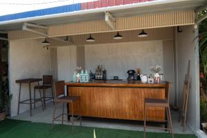 a patio with a bar with stools under awning at La Casa Josefina in Aga +38 photos