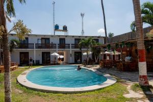 a swimming pool in front of a building at Hotel Luna Nueva in Colán
