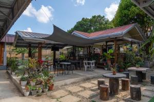 a patio with a black canopy and tables and plants at La Casa Josefina in Aga