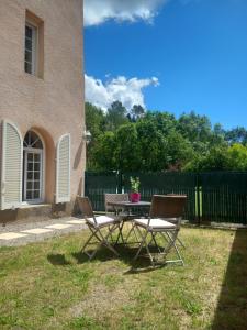 a picnic table and two chairs in a yard at Charmante chambre d'hôtes "CARLA" avec piscine, Château de Favas in Bargemon