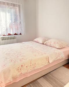 a bedroom with a bed with pink sheets and a window at Apartment Green Heaven in Konjic