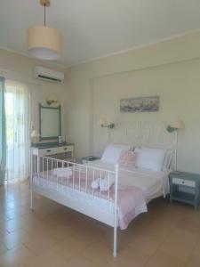 a bedroom with a white bed and a mirror at Romantic Apartment in Adelianos Kampos