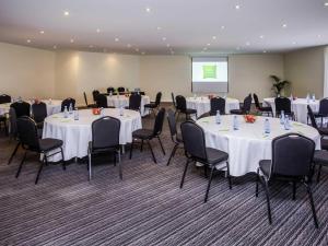 a conference room with tables and chairs and a screen at ibis Styles Canberra Eagle Hawk in Canberra +55 photos