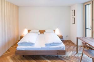 a bedroom with a bed with white sheets and pillows at Hotel Krone in Au in Au im Bregenzerwald