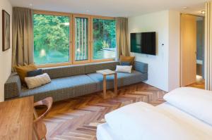 a living room with a couch and a large window at Hotel Krone in Au in Au im Bregenzerwald