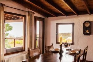 a dining room with a table and two windows at Finca Vilaflor in Vilaflor